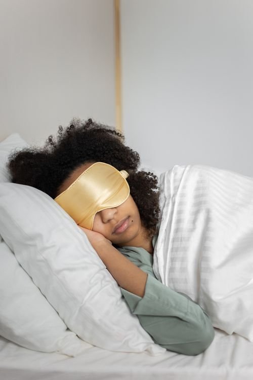 Woman wearing a sleep mask resting peacefully in bed